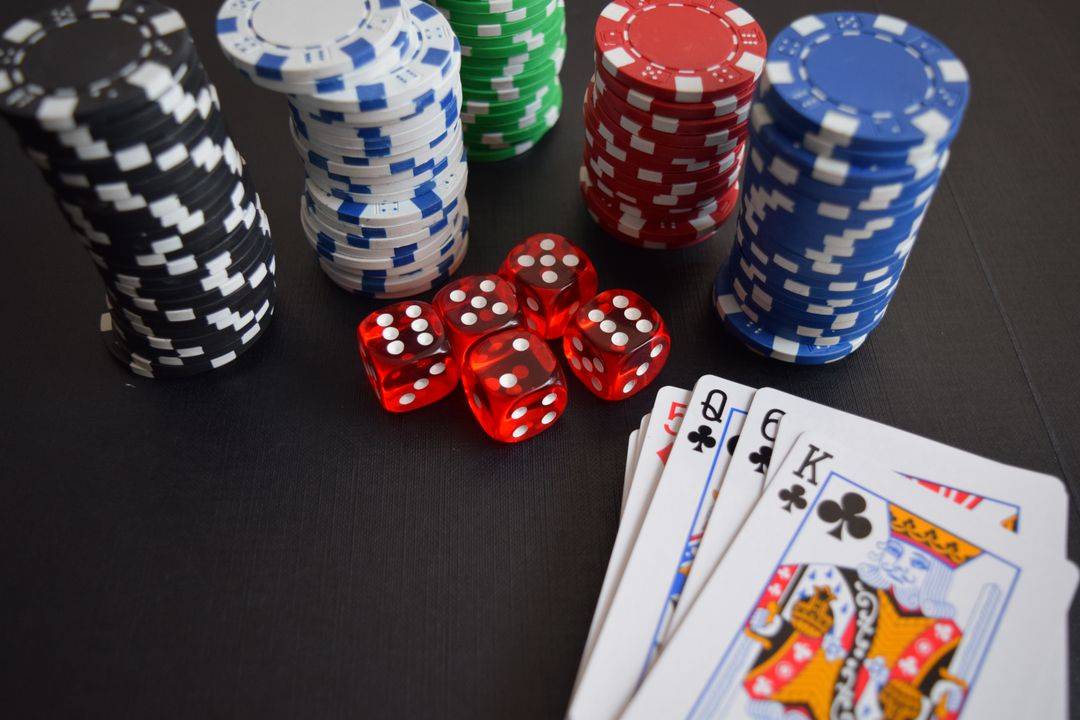 Chip poker, kartu remi, dan dadu di atas meja kasino