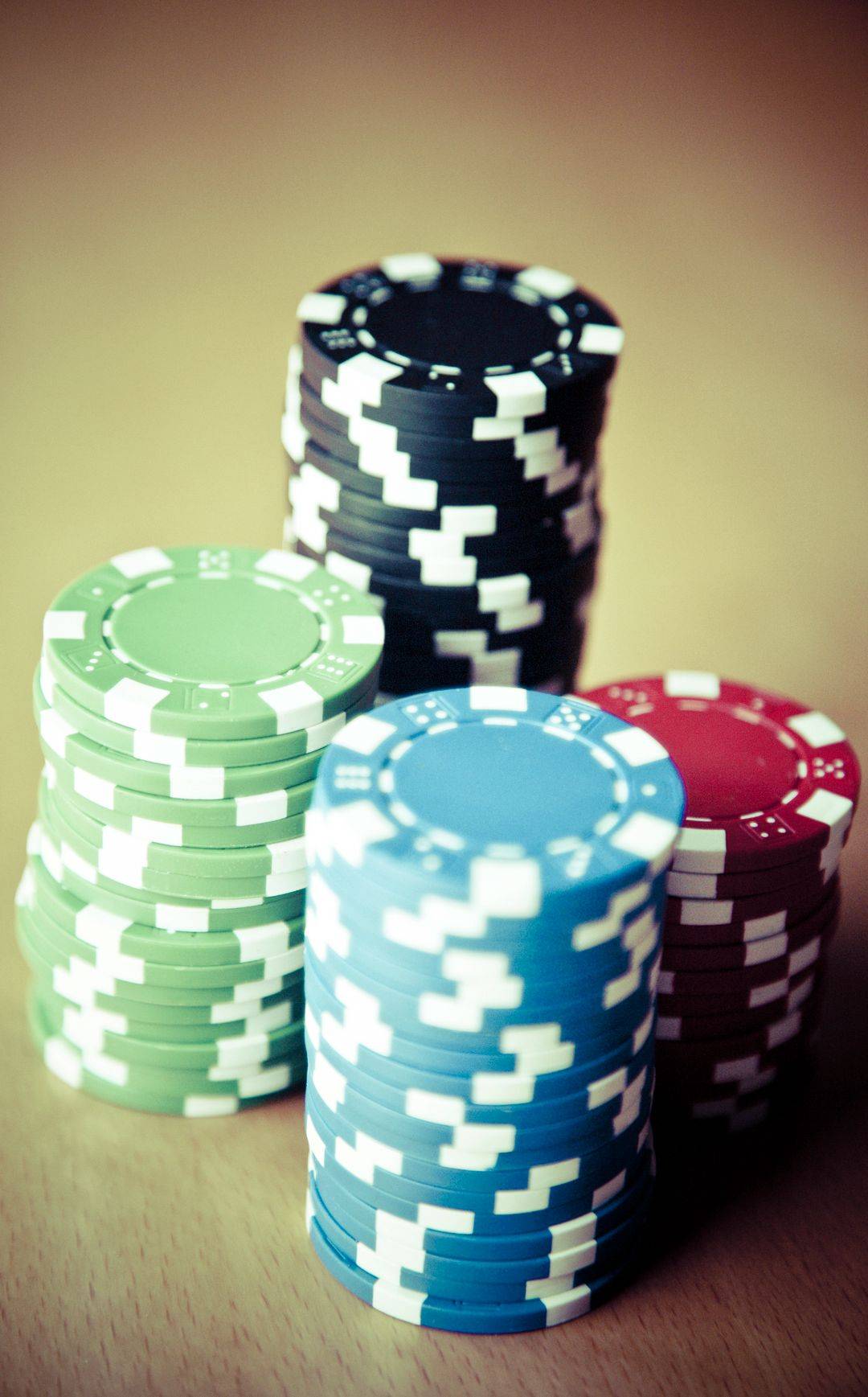 Chip kasino berwarna-warni tertata di atas meja