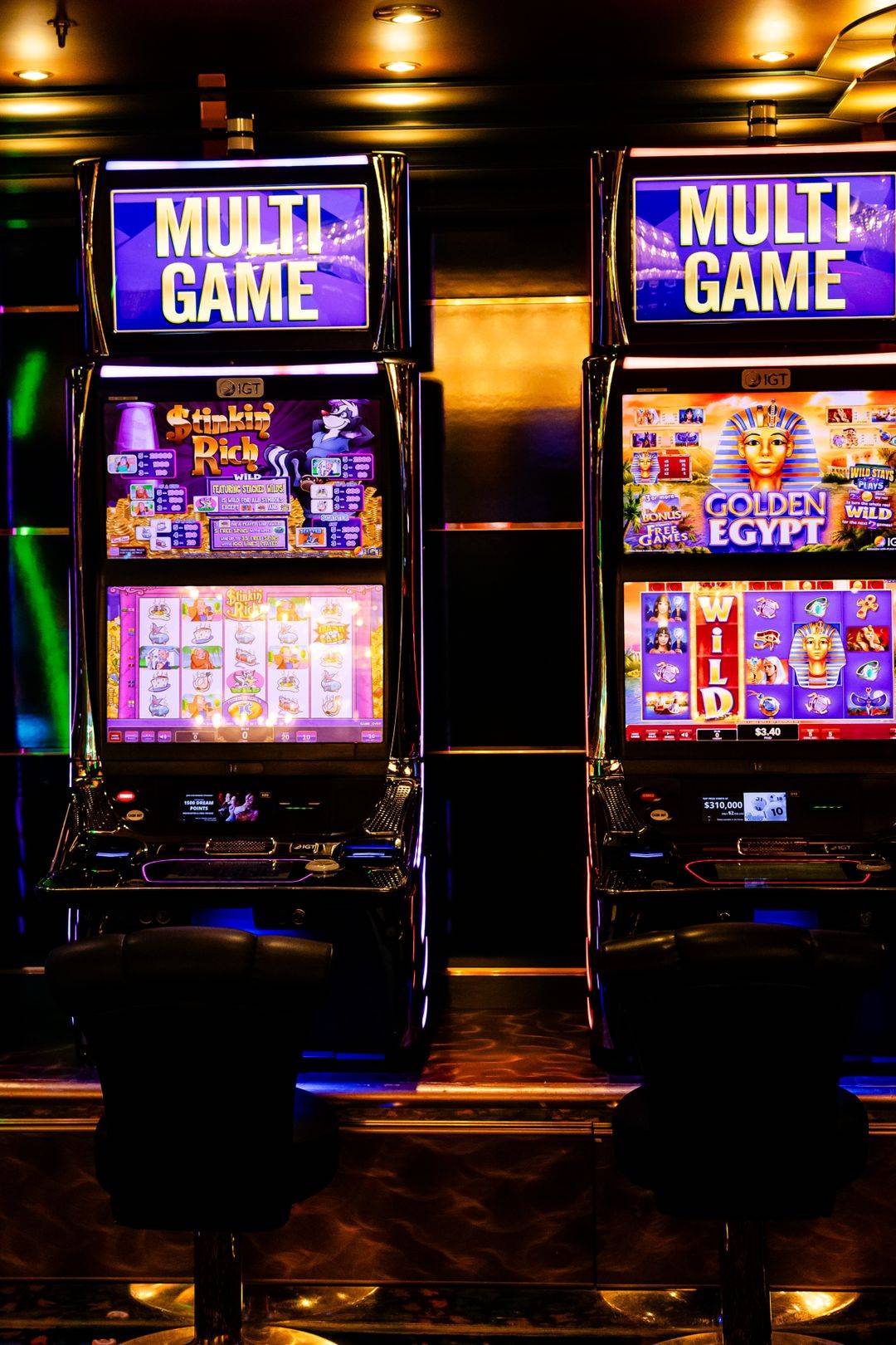 Deretan mesin slot dengan lampu warna-warni di kasino